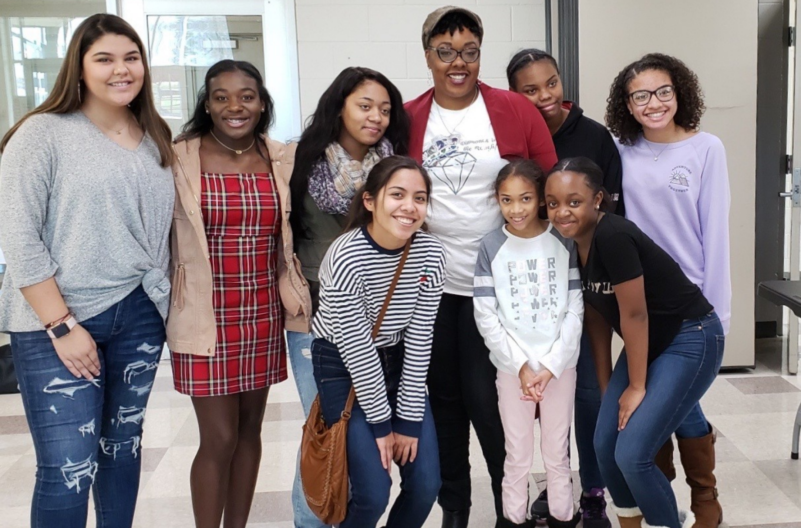 The founder in Diamonds in the Rough shirt among happy, smiling teenage girls at a DITR event